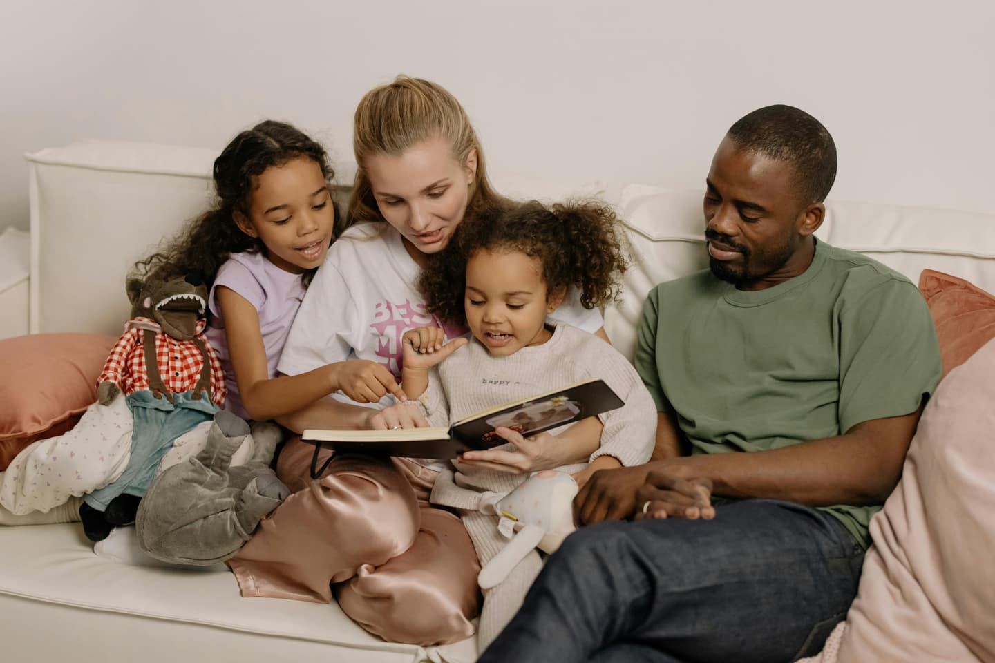 Mixed-raced family reading on sofa